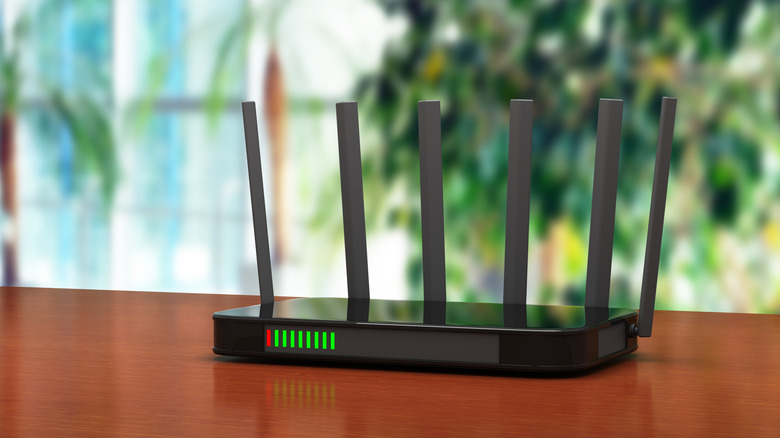 black wi-fi router with multiple antennas placed on a wooden desk