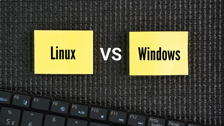 Linux versus Windows sticky notes above a keyboard.
