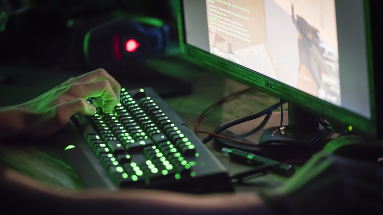 Zoomed-in view of someone using a keyboard with green lit-up keys