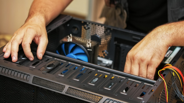 A person repairing and modifying an open PC case