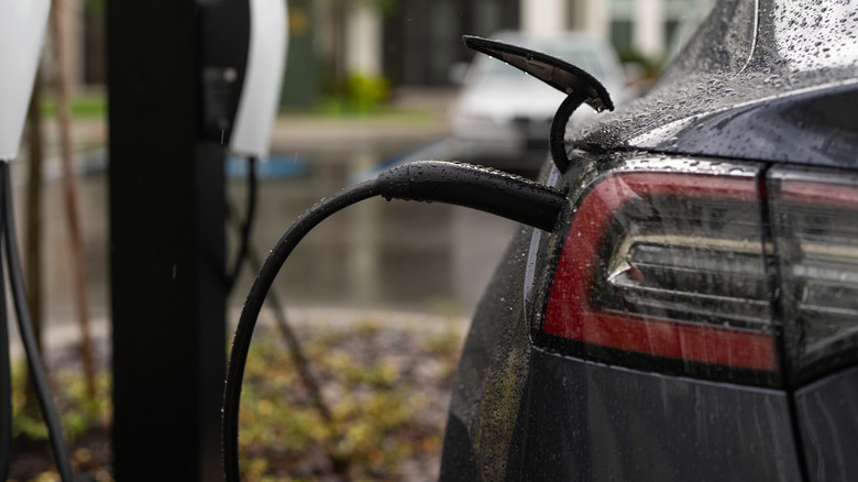 Electric car charging in the rain at a public charging station