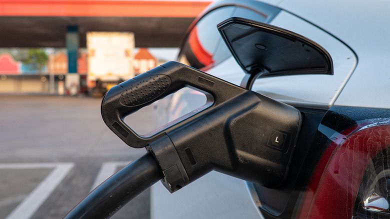 Electric vehicle charging connector plugged into the car's rear charging port