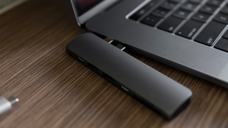 Multi-port laptop docking station being connected to a laptop's USB ports.