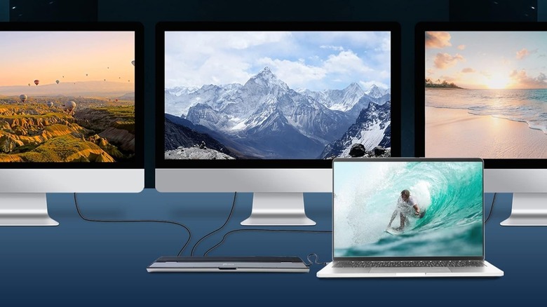 j5create docking station plugged into three monitors and a laptop.