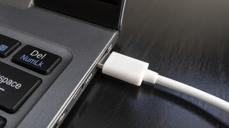 USB Type-C cable plugged into the side of a laptop as a close up.