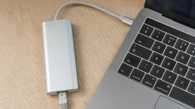 USB-C docking station plugged into a laptop on a desk.