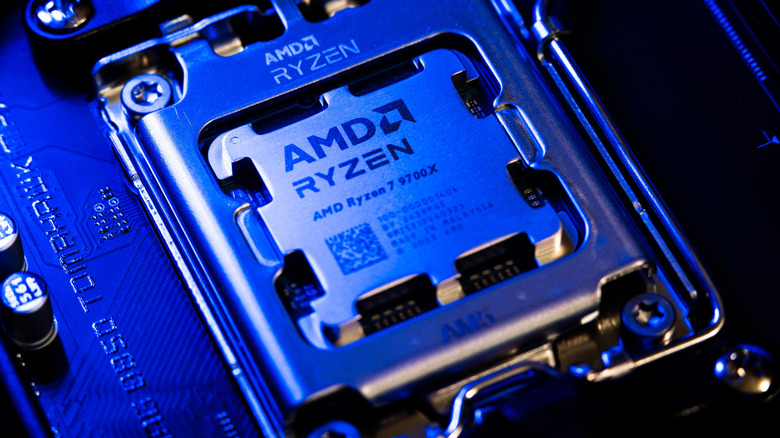 AMD Ryzen 7 9700X processor installed in a motherboard socket under blue lighting.