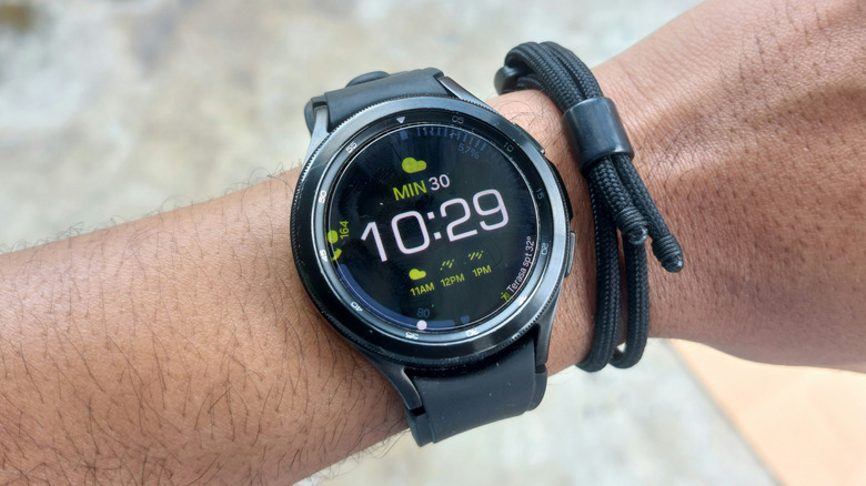 A closeup view of a black Samsung Galaxy Watch 4 lays on a user's wrist