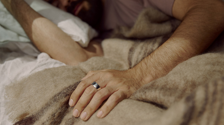 A man sleeping while wearing an Oura Ring 4.