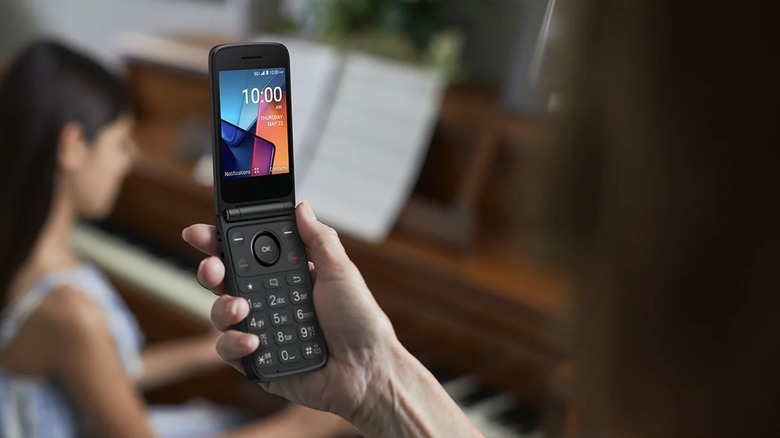 Someone holding the TCL Flip 4 5G flip phone.