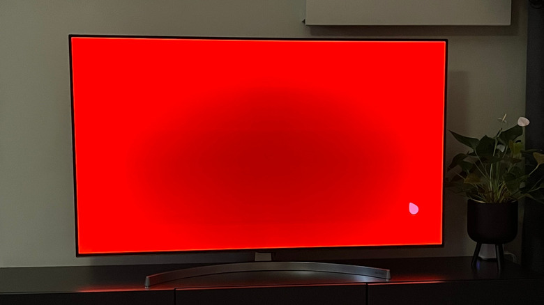 TV displaying a mostly red screen with burn-in in the center.