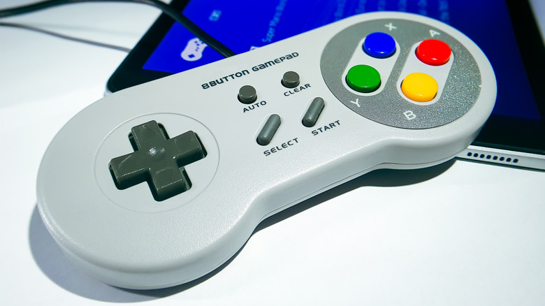 A retro gaming controller resting on a tablet