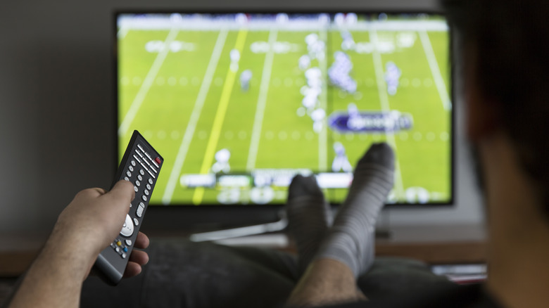 Pointing a remote at a TV with a football game on