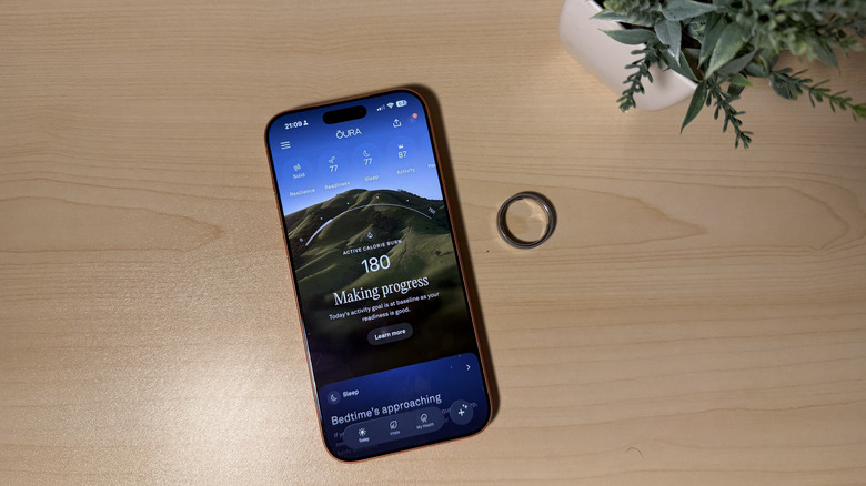 Oura Ring 5 on table next to an iPhone with the app open