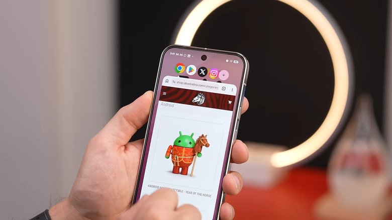Hand holding Android showing app bubbles