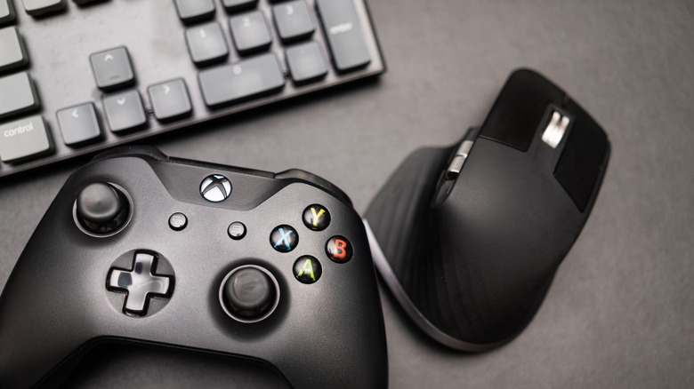An Xbox controller next to a mouse and keyboard.