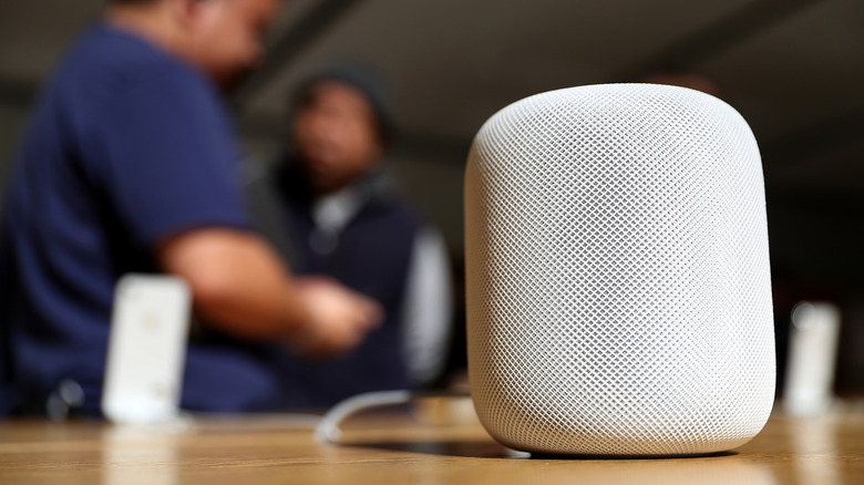 A white Apple HomePod set up on a table