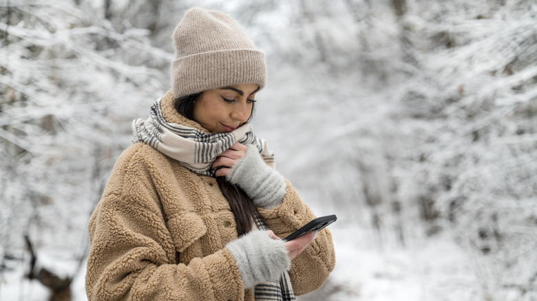 Woman using a smartphone during the winter