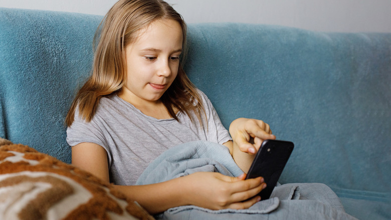 A child doing a flicking motion on a smartphone