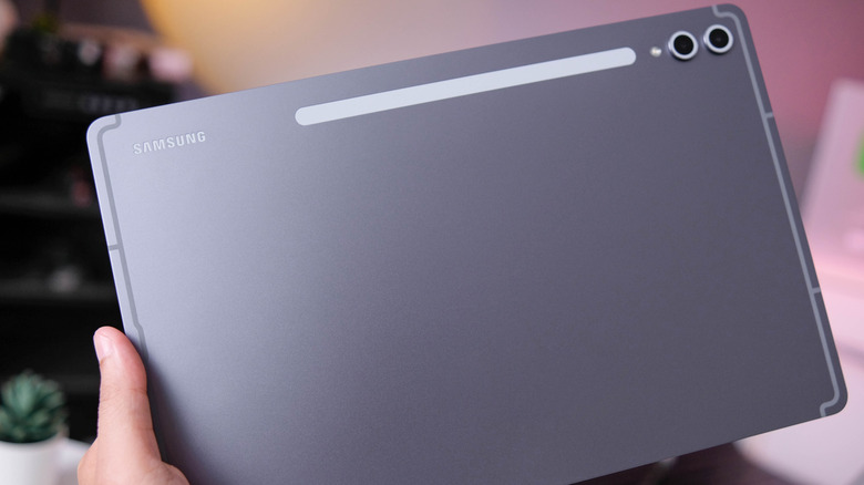 A person holding a Samsung Galaxy Tab S10+