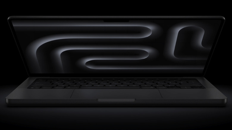 A black MacBook Pro on a dark background with a glowing white design on the screen