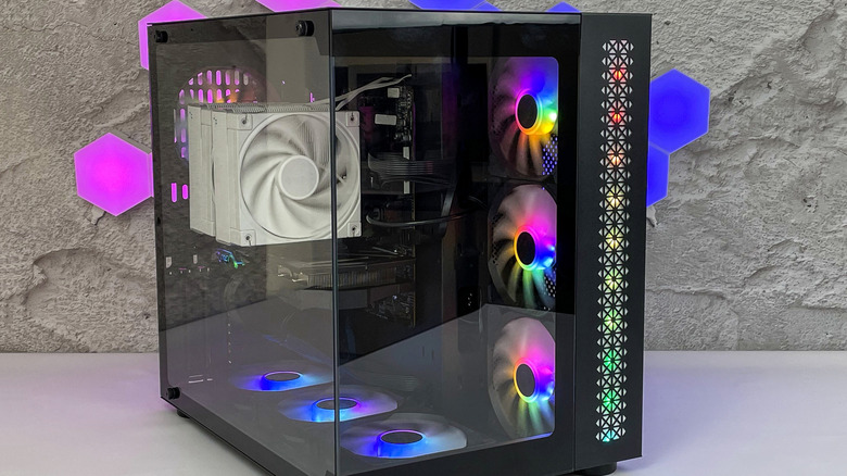 black gaming PC case with glass panels and RGB lighting placed on a white table
