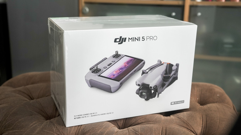 DJI mini 5 PRO drone box placed on a brown cushion
