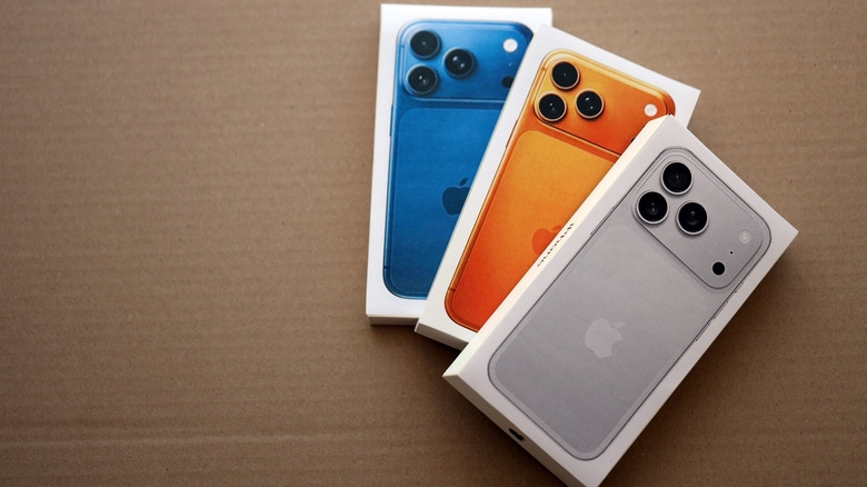 three iPhone 17 pro phones inside their packaging box placed on a cardboard