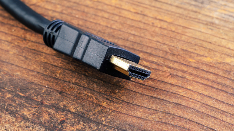 An HDMI cable sitting on a wood-tone desk