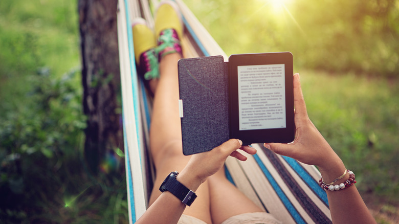Woman reading on Kindle on hammock