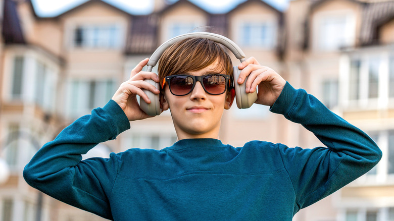 a young man wearing headphones and looking at the camera