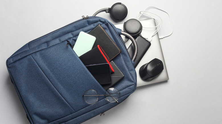 a blue backpack with gadgets spilling out of it