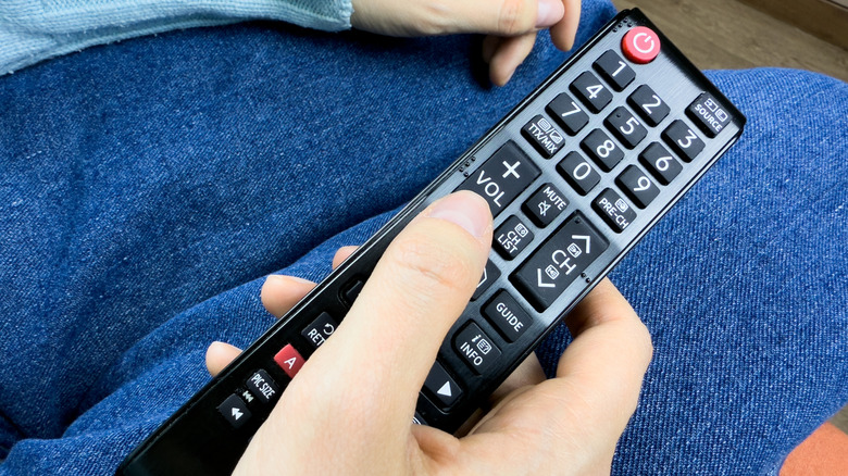 Adjusting the volume on a TV remote.