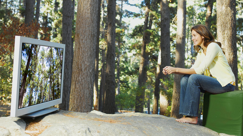 Person watching a TV outside