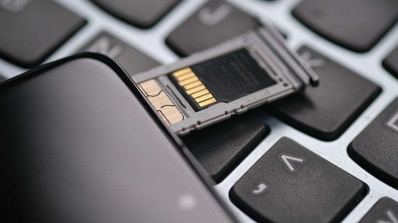 A picture of a microSD card in a hybrid SIM tray on a smartphone