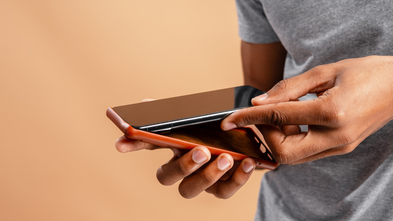 A person inserting a phone into a case