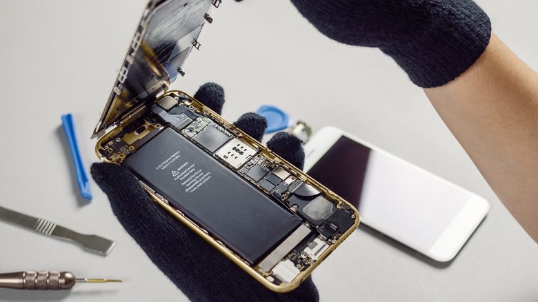 a person opening the back of a smartphone