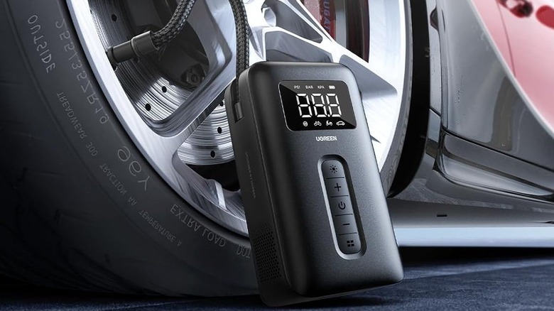 Close-up of a car tire being inflated with UGREEN Tire Inflator