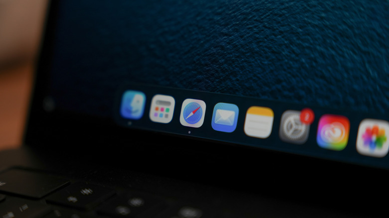 macbook screen displaying the macOS dock with apps like Safari, Notes, Mail, Settings, and Photos