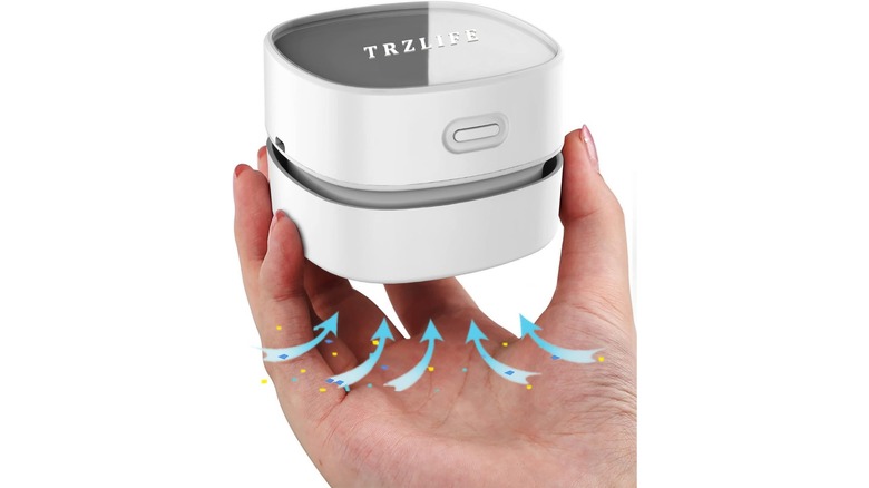 An Amazon promotional photo for the TRZLIFE Desk Vacuum Cleaner, the item is held in the palm of someone's hand
