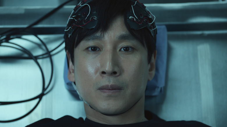 Sewon Koh lying on a table with wires connected to his head in "Dr. Brain."