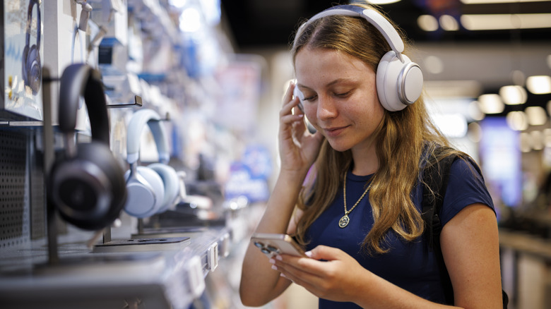 Girl testing over-ear headphones in store