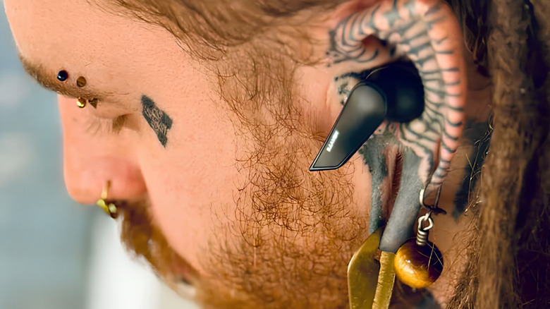 A man wearing Heavys H1E earbuds