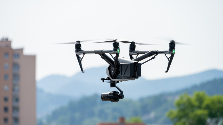 View of drone with camera flying over city.