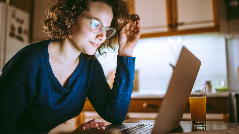 Young woman looking at the screen of a laptop and smiling