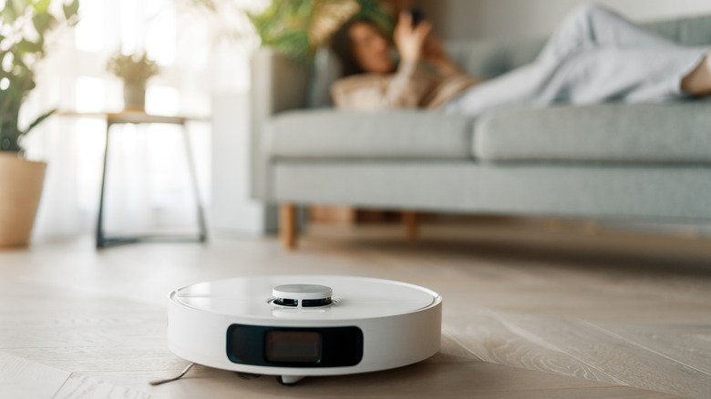 White robotic vacuum cleaner on wooden floor