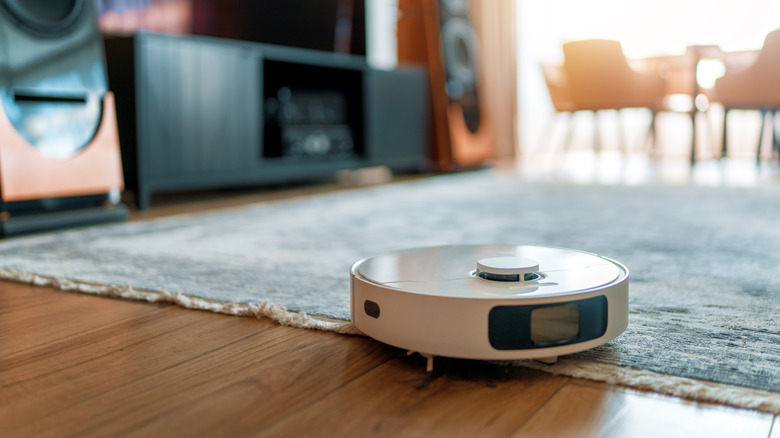 White robotic vacuum cleaner on wooden floor