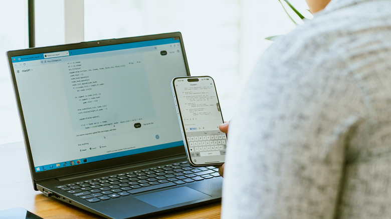 A person using ChatGPT mobile and on a laptop.