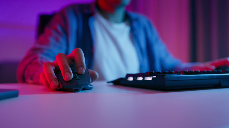 Person using a mouse and keyboard on desk