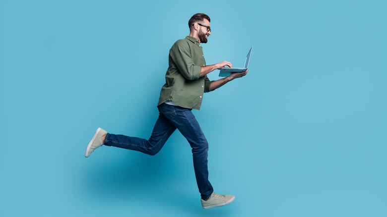 Man typing on a laptop on the run